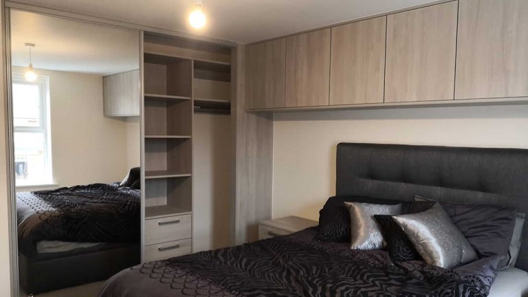 bedroom with matching sliding wardrobes and cupboards
