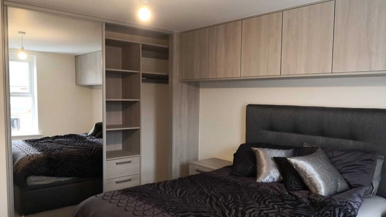 bedroom with matching sliding wardrobes and cupboards
