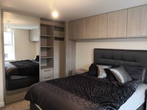 bedroom with sliding wardrobes and matching cupboards